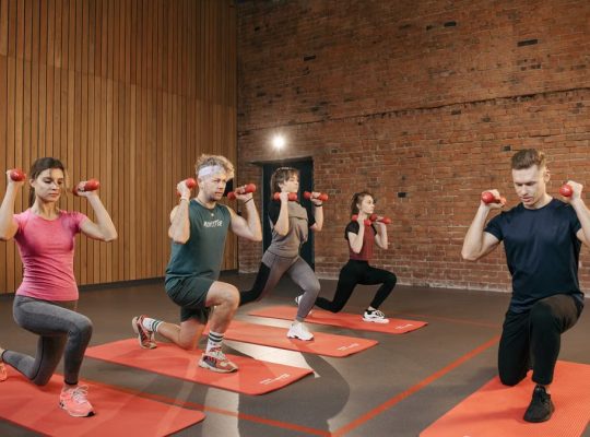 Indoor group workout session with dumbbells focusing on strength and fitness.